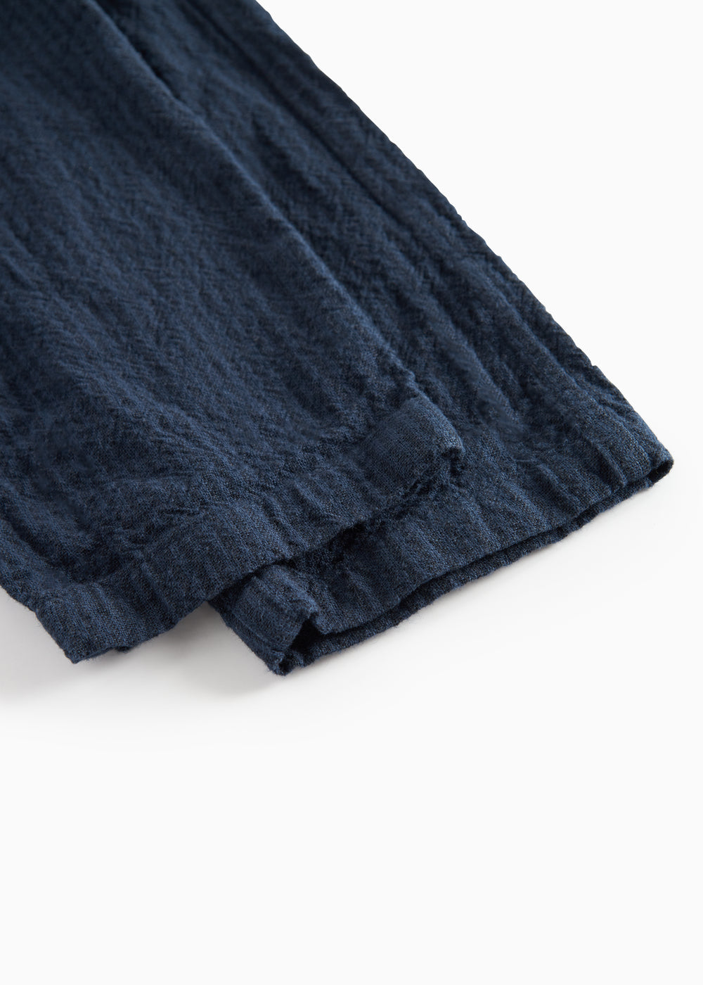 Detaljebillede af stof og søm på mørkeblå bukser