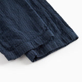 Detaljebillede af stof og søm på mørkeblå bukser