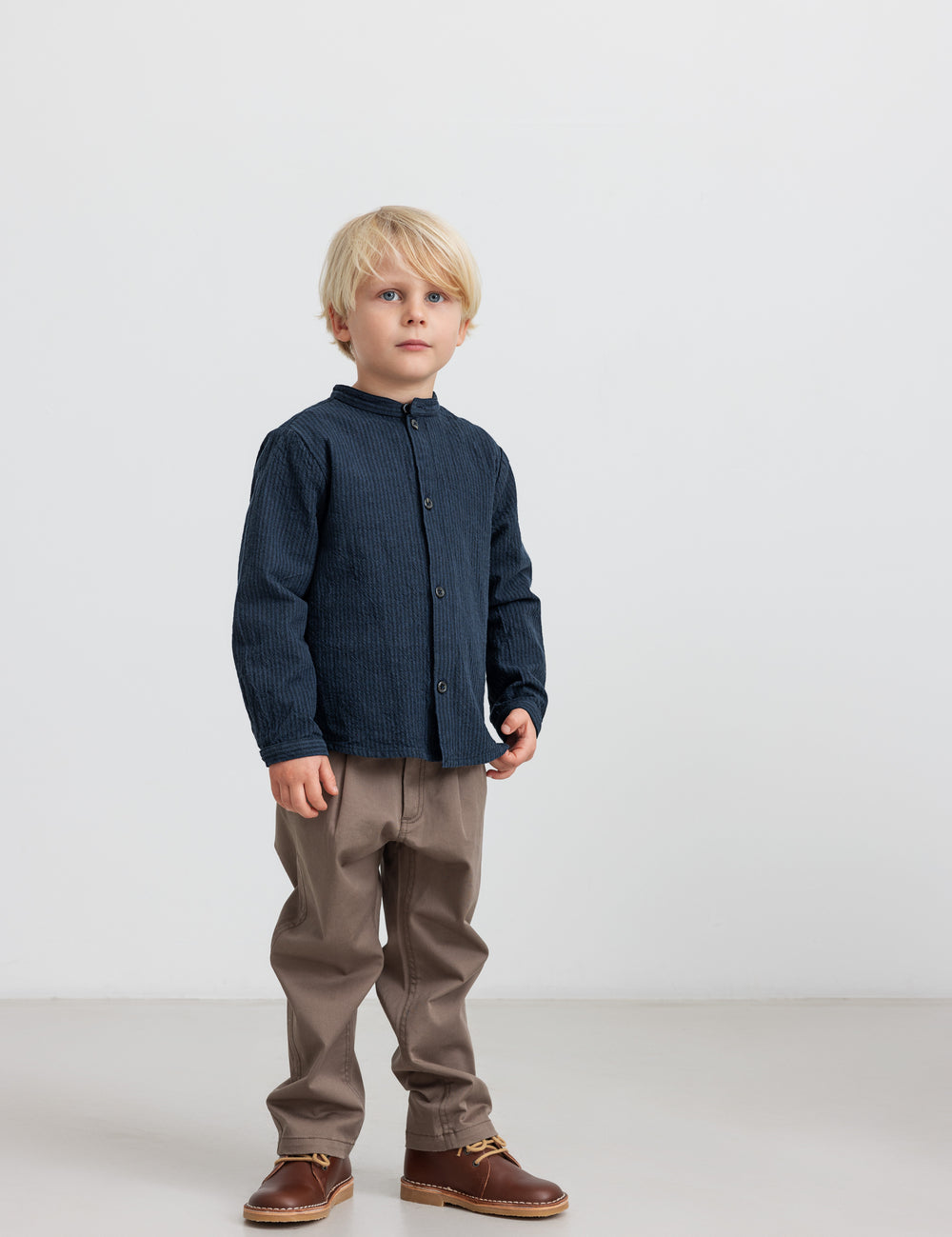 Dreng iført en blå jakke og kaki bukser