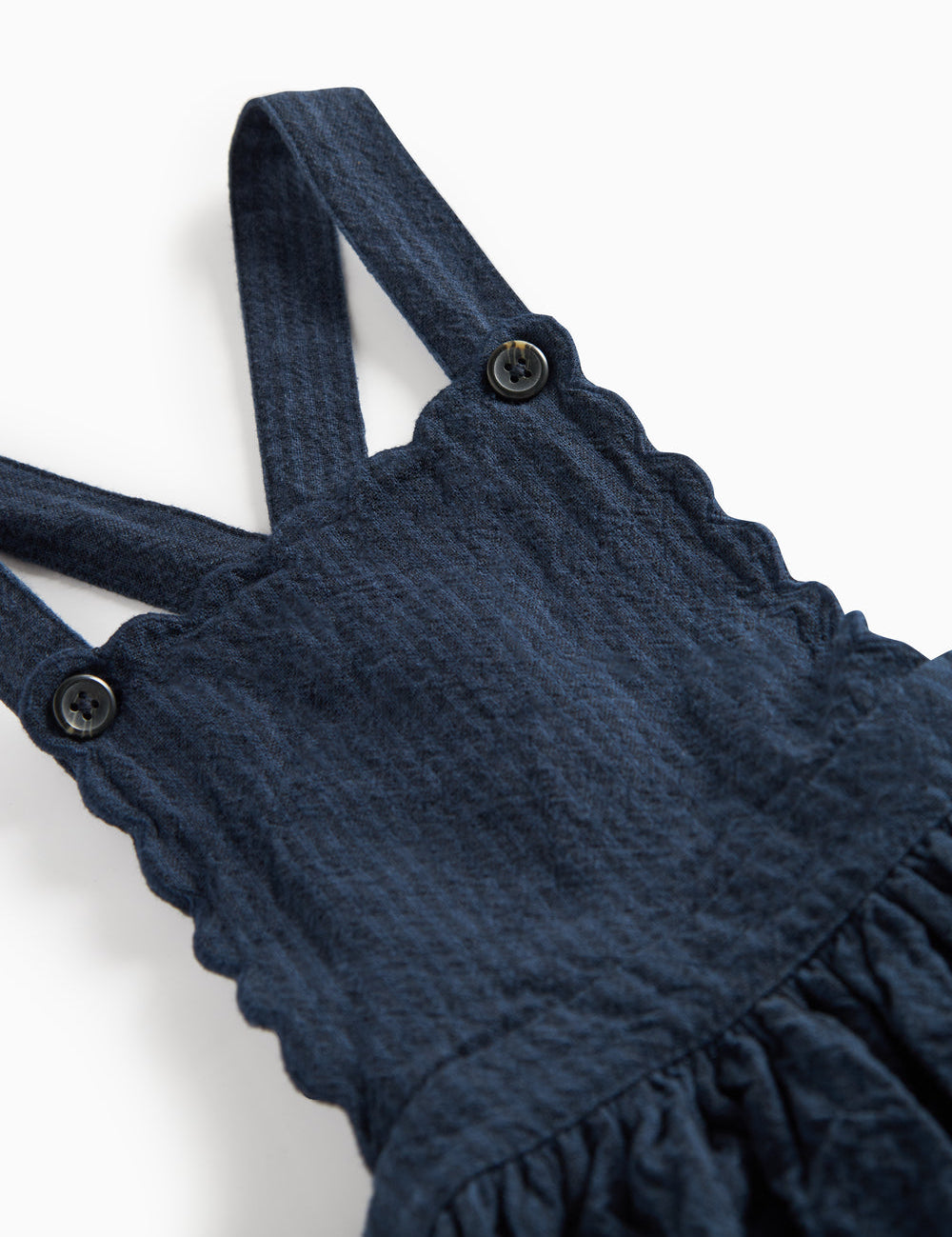 Detaljebillede af knapper på stropperne på mørkeblå selekjole