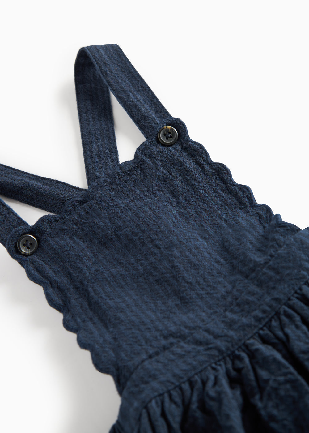 Detaljebillede af knapper på stropperne på mørkeblå selekjole