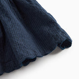 Detaljebillede af skørtets bølgede kant på mørkeblå selekjole