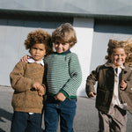 Gruppe børn iført striktrøjer og jakker ude i naturen