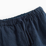 Detaljebillede af elastik i taljen på mørkeblå bukser