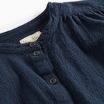 Detaljebillede af mørkeblå bluse med knapper foran