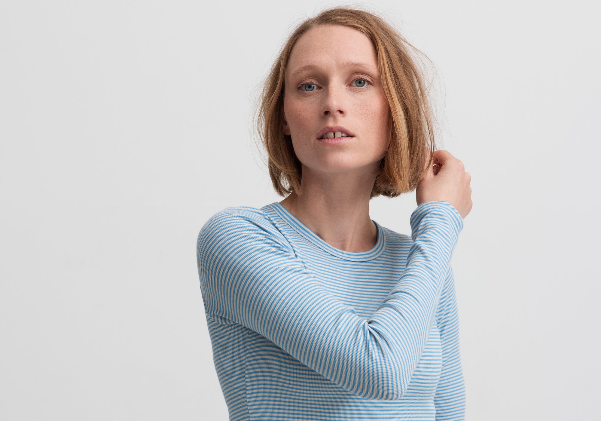 Kvinde i langærmet t-shirt med lyseblå og hvide striber