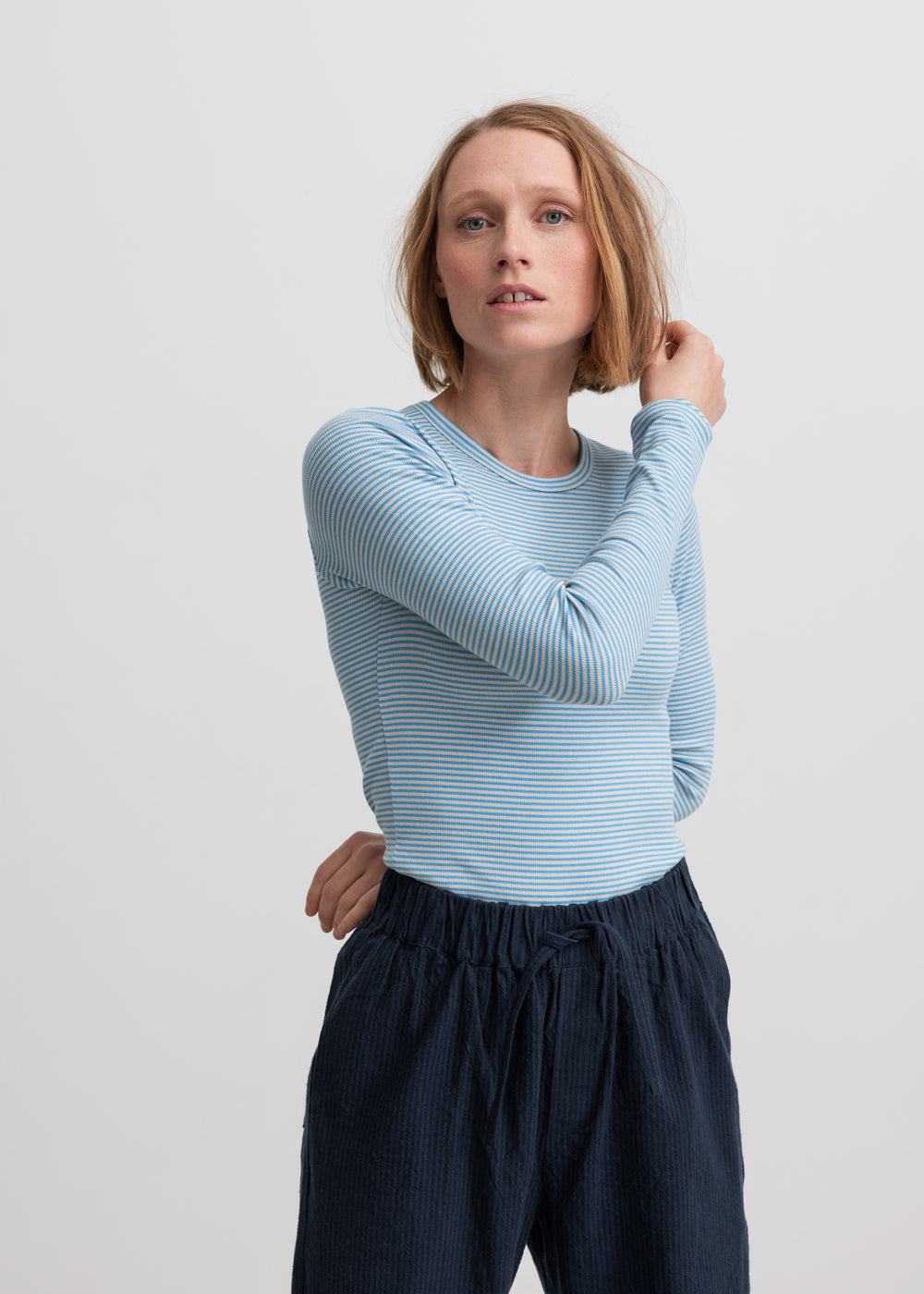 Kvinde iført mørkeblå bukser og lyseblå trøje