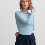 Kvinde iført mørkeblå bukser og lyseblå trøje