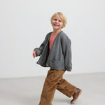 Dreng i brun fløjlsbuks med grå strikket cardigan