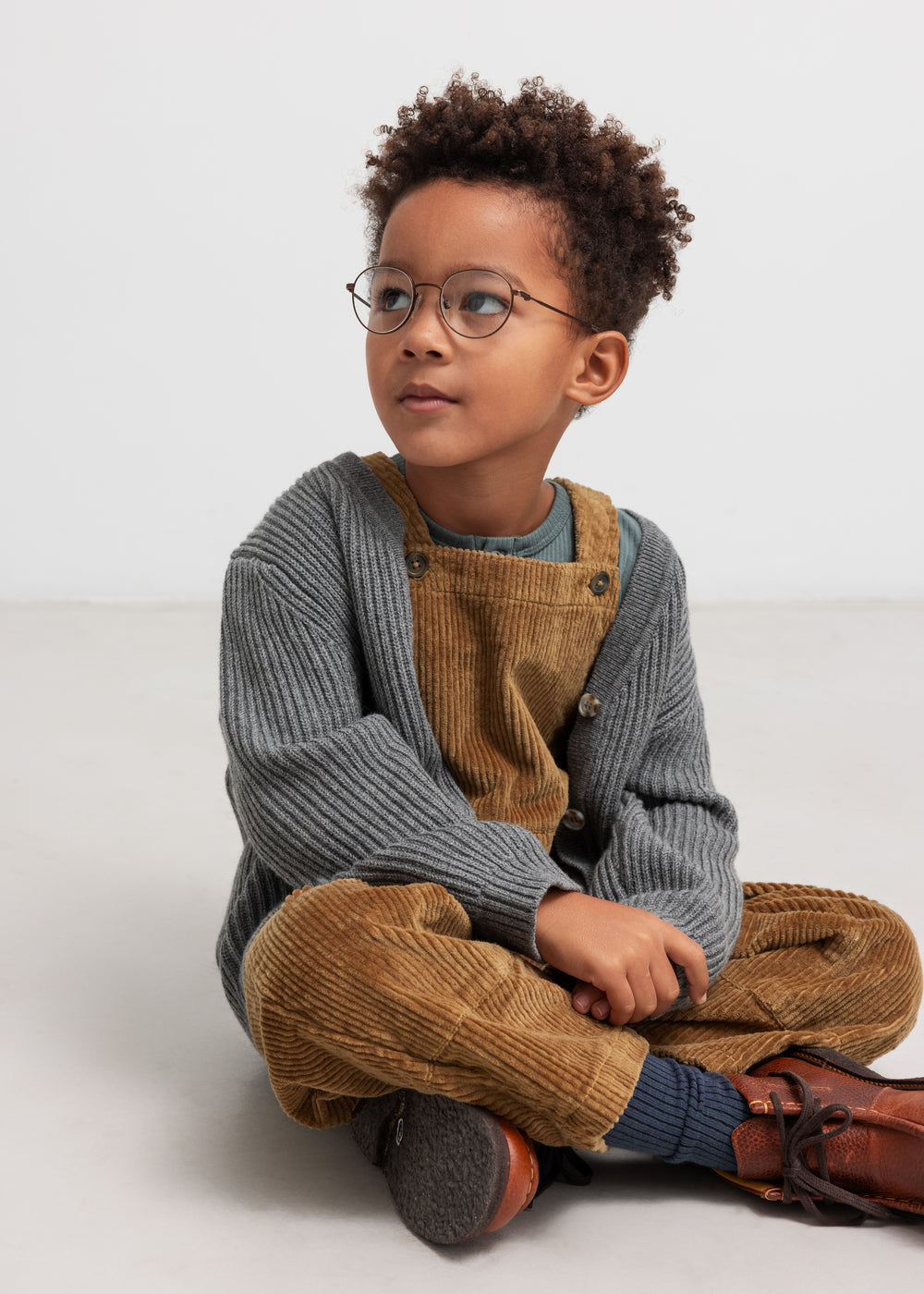 Dreng i brune fløjlsoverall med grå striktrøje og briller