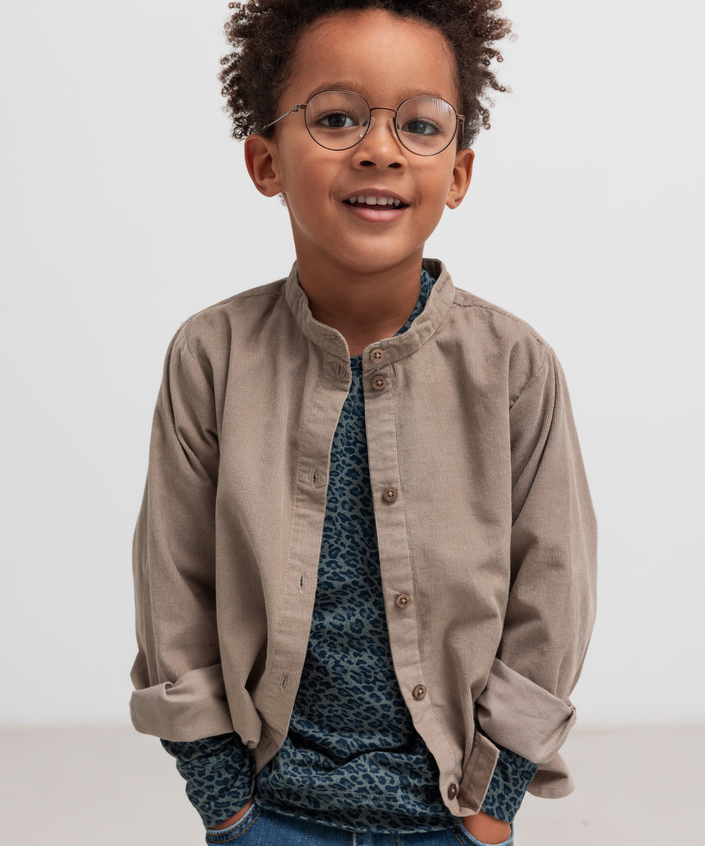 Dreng iført beige babyfløjlsskjorte og mørkeblå bluse