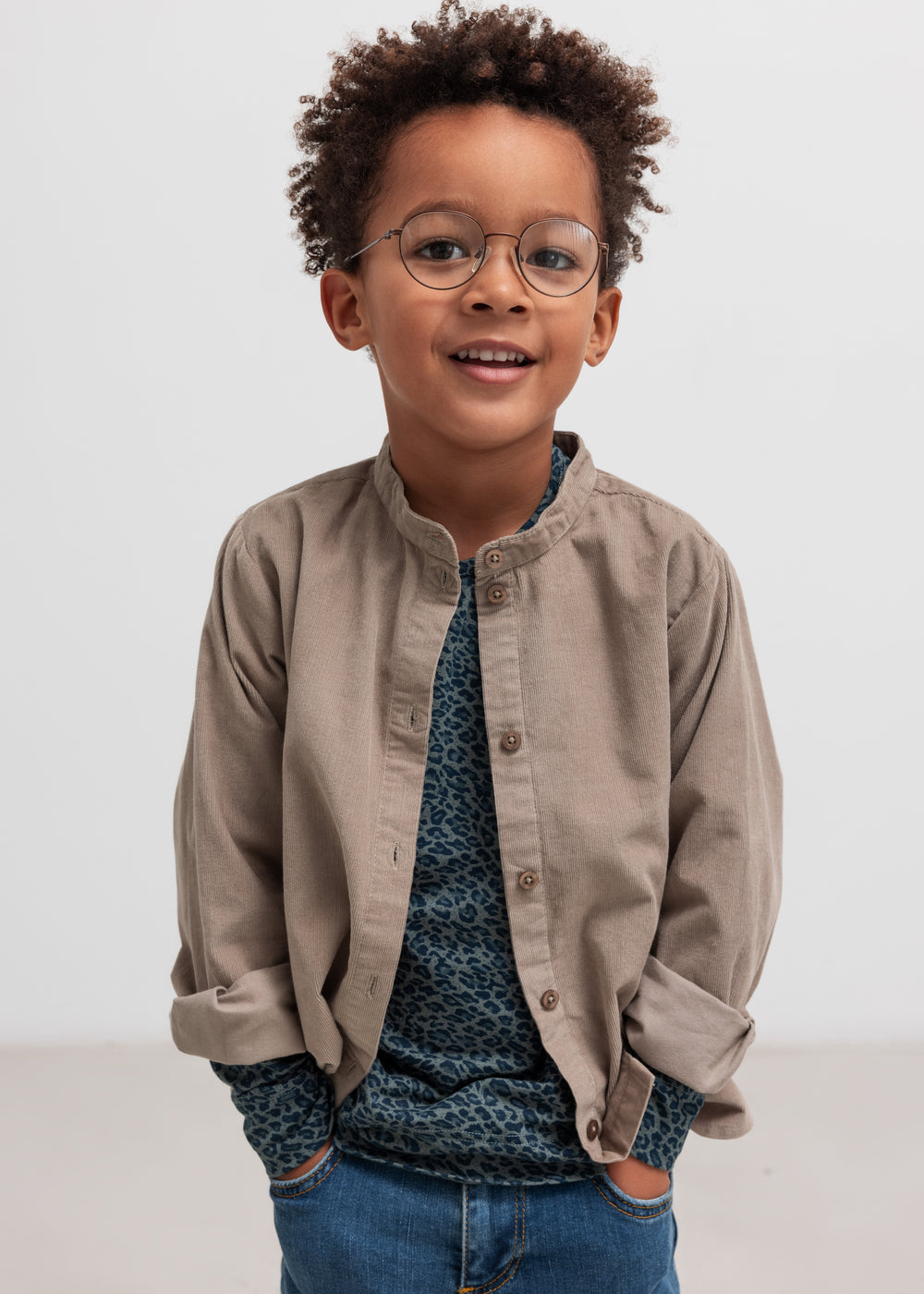 Dreng iført beige babyfløjlsskjorte og mørkeblå bluse