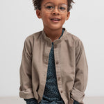 Dreng iført beige babyfløjlsskjorte og mørkeblå bluse