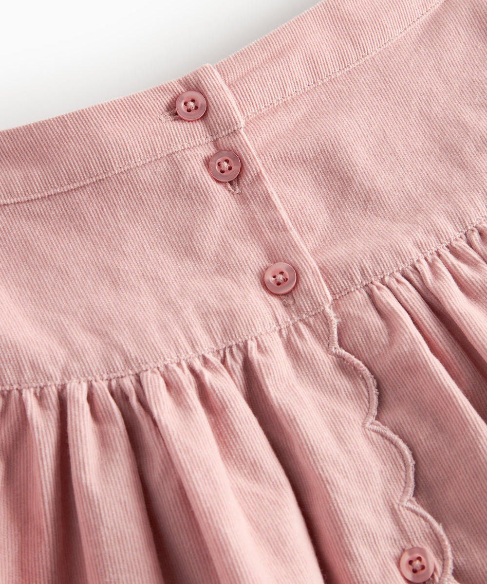 Lyserød nederdel i babyfløjl med knapper og bølgekant til børn