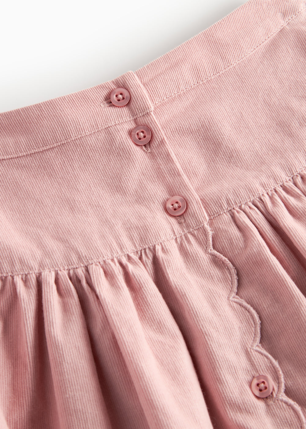 Lyserød nederdel i babyfløjl med knapper og bølgekant til børn