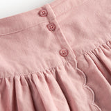 Lyserød nederdel i babyfløjl med knapper og bølgekant til børn