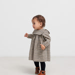 Lille børn iført brun ternet kjole i crepet bomuld