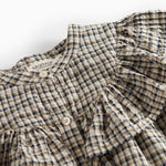 Detalje af flæser på brun ternet strikkjole