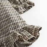 Detalje af flæser på brun ternet strikkjole