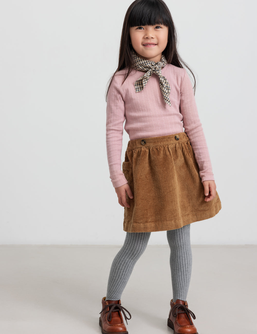 Girl wearing brown velvet skirt and pink blouse
