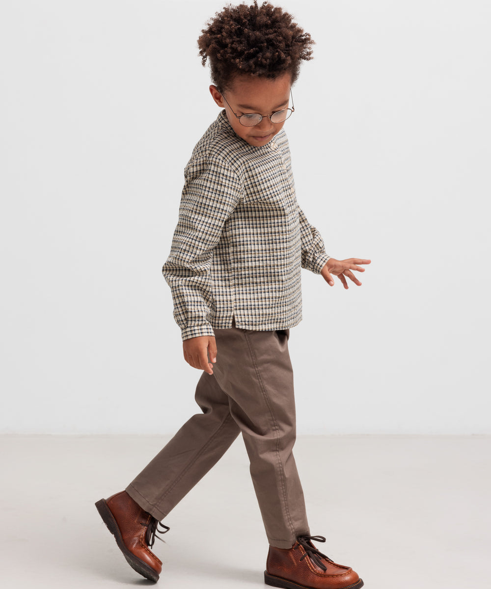 Dreng iført stribet trøje og kaki bukser