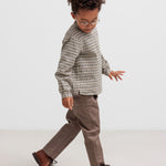 Dreng iført stribet trøje og kaki bukser