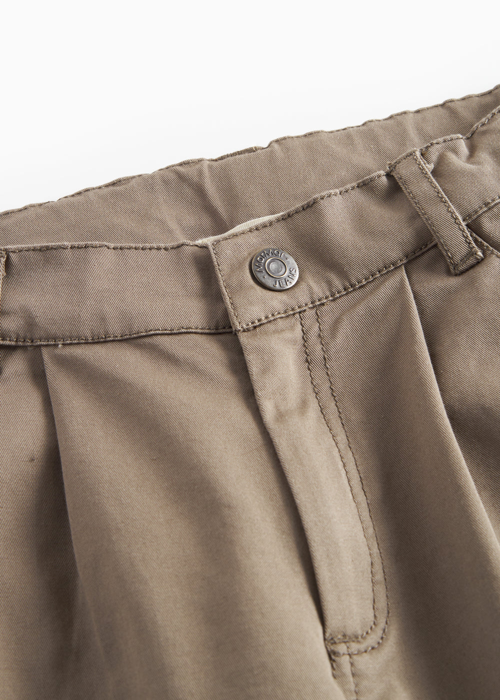 Detaljebillede af knaplukning på kaki bukser