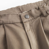 Detaljebillede af knaplukning på kaki bukser