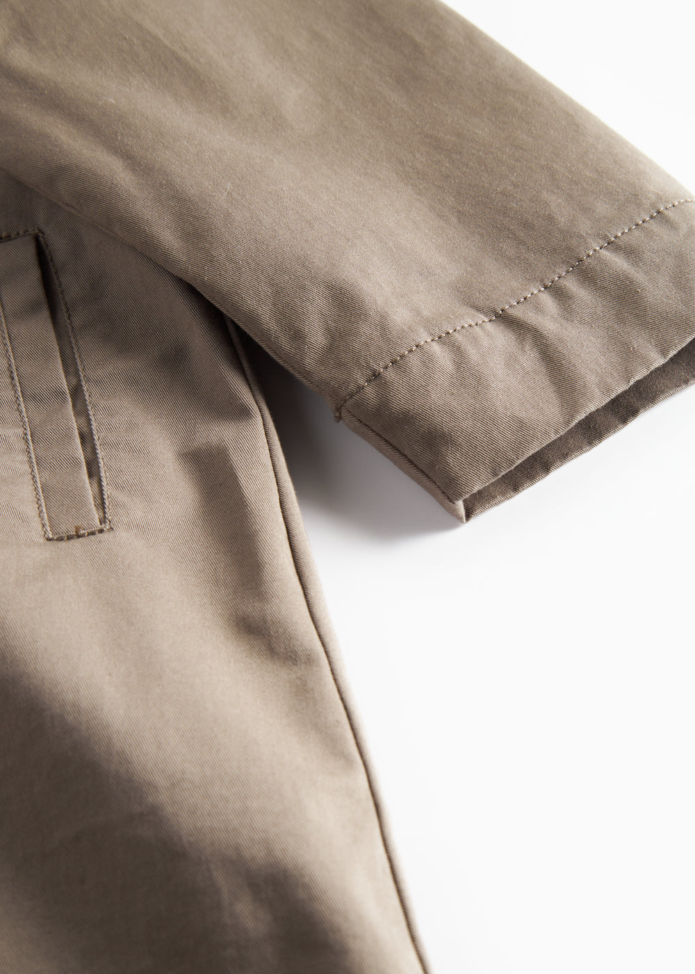 Detaljebillede af ærme og lomme på kaki chino frakke