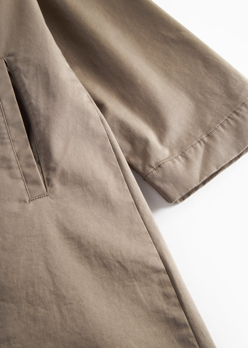 Detaljebillede af ærme og lommer på kaki chino frakke