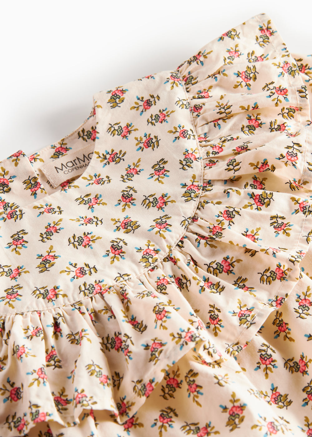 Nærbillede af kjole med blomstermønster og flæser