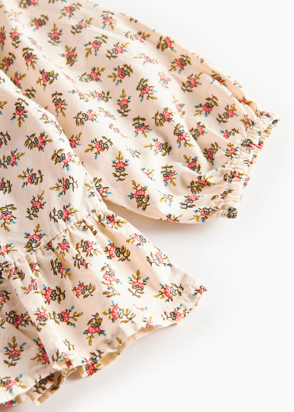 Nærbillede af kjole med blomstermønster og flæser