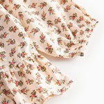 Nærbillede af kjole med blomstermønster og flæser