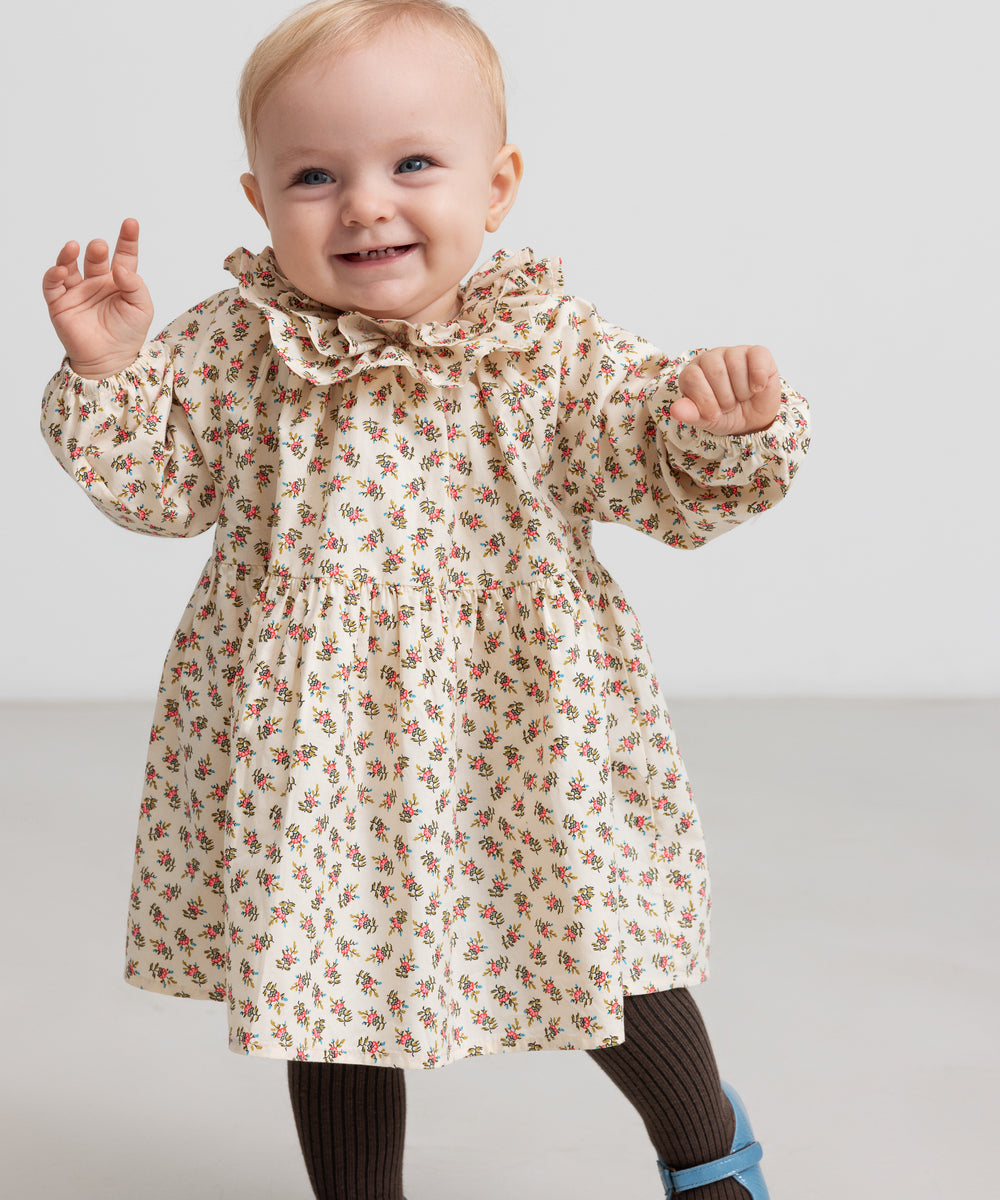 Børn iført kjole med blomstermønster og flæsekrave