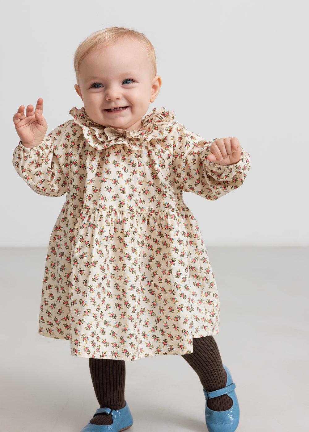Børn iført kjole med blomstermønster og flæsekrave