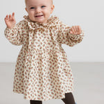 Børn iført kjole med blomstermønster og flæsekrave