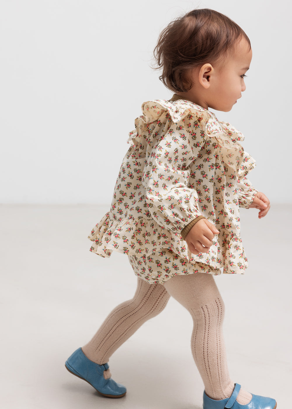 Baby iført bloomers med blomsterprint og elastisk talje