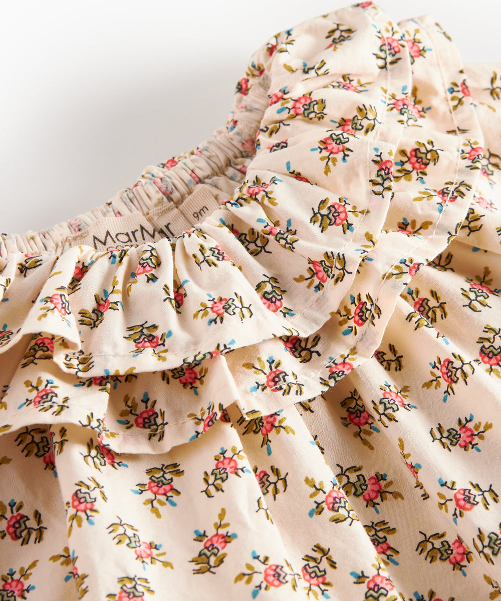 Detaljebillede af kjole med blomstermønster og flæsedetaljer