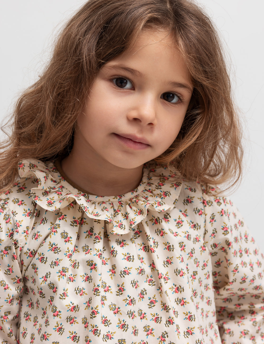 Børn i bluse med blomstermønster og flæsekrave