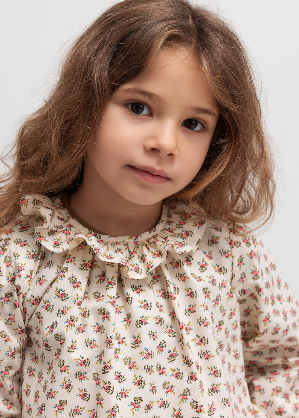 Børn i bluse med blomstermønster og flæsekrave