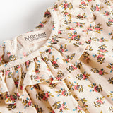 Detaljebillede af bluse med blomstermønster og flæsedetalje