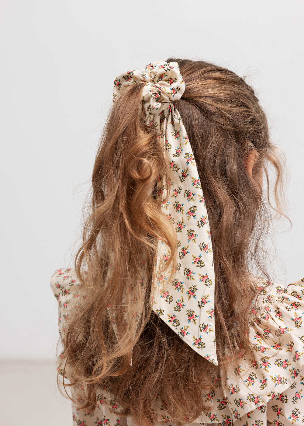 Hårelastik med blomsterprint bundet i hår