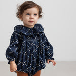 Baby iført mørkeblå blomstermønstret heldragt