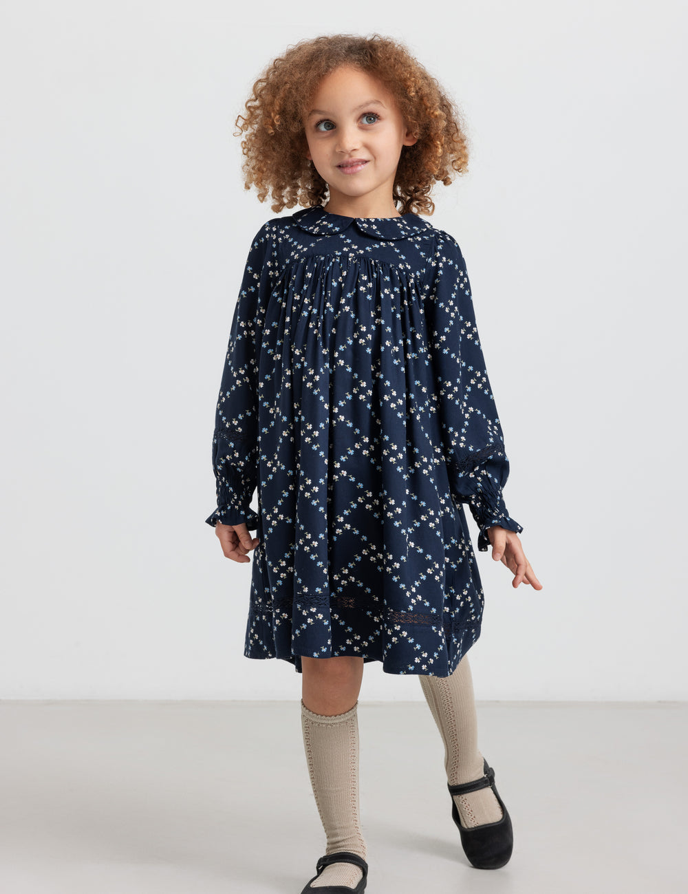 Pige iført mørkeblå blomstermønstret kjole