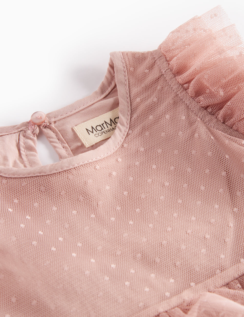 Detail of pink tulle dress with polka dot pattern and ruffles at the neck
