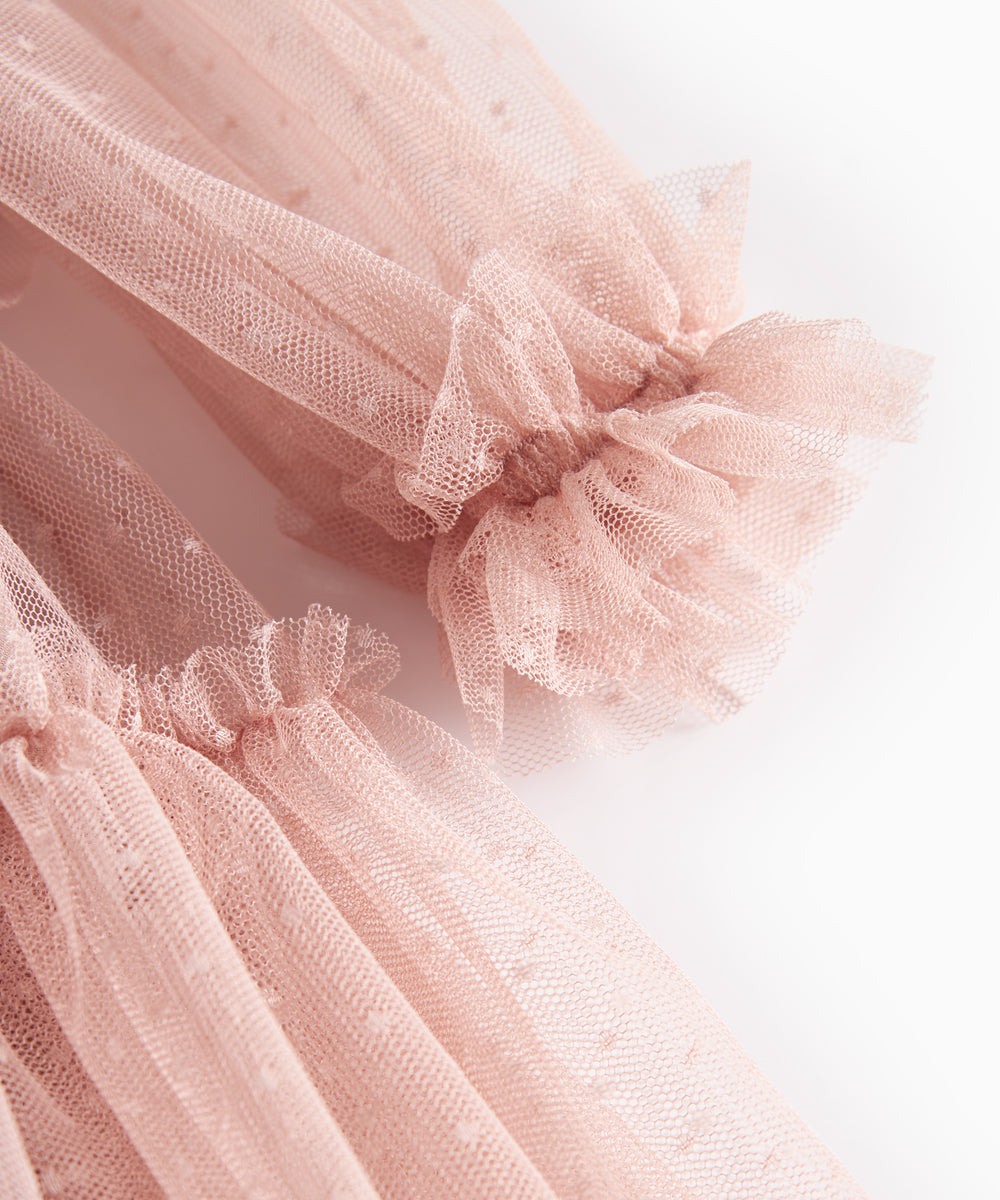 Nærbillede af lyserød tylkjole med elastiske manchetter og flæser