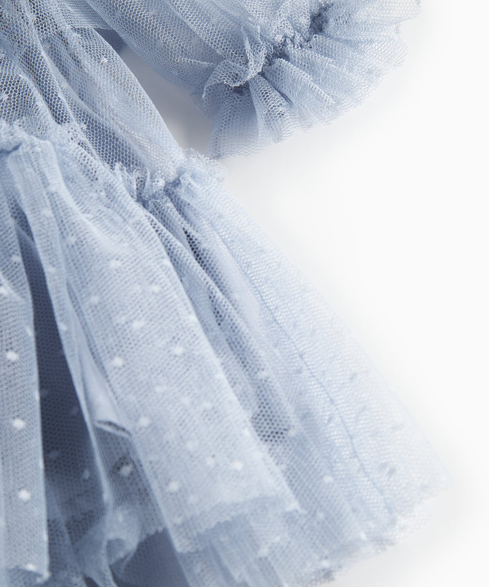Nærbillede af blå tylkjole med let stof og flæsedetaljer