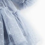 Nærbillede af blå tylkjole med let stof og flæsedetaljer