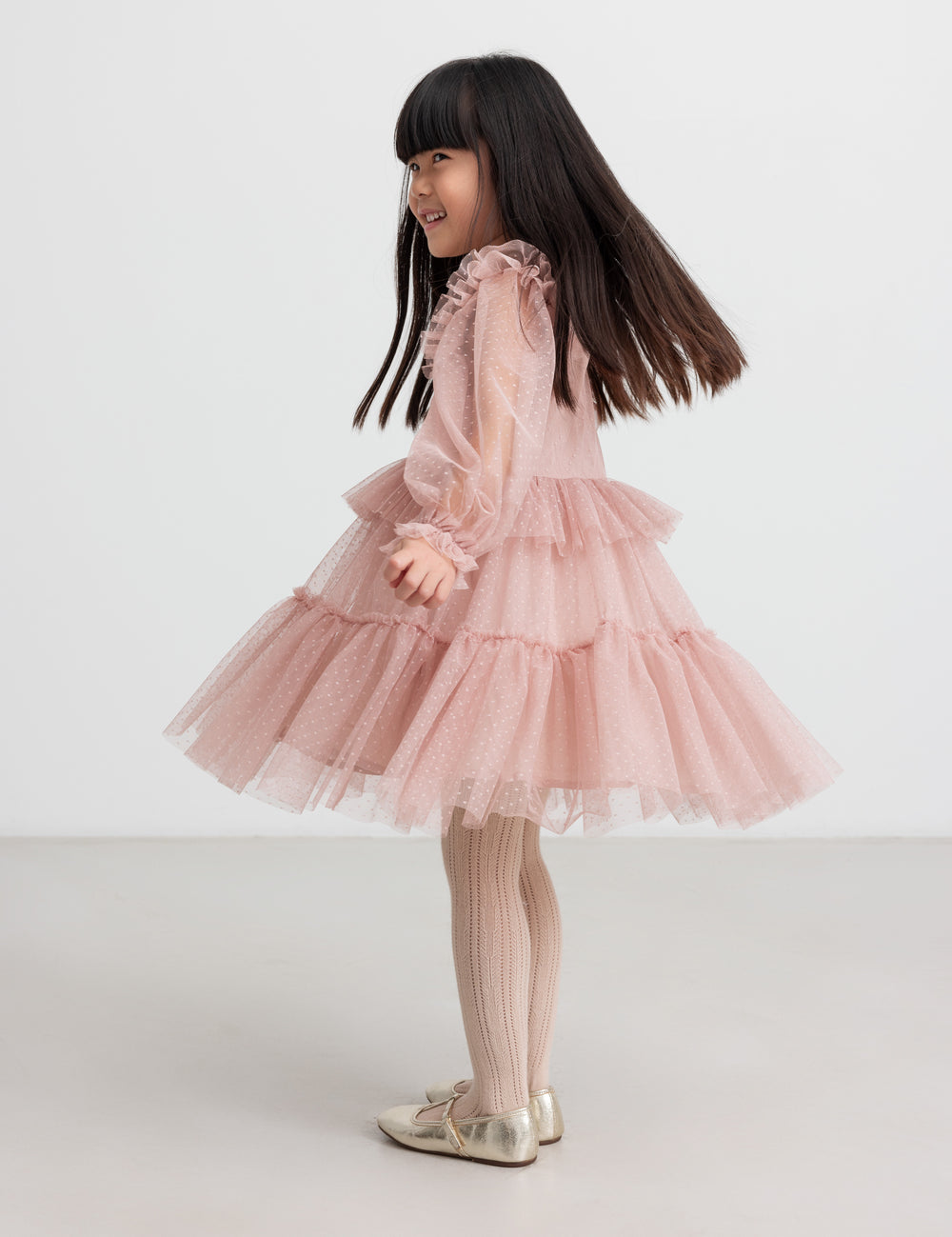 Børn iført rosa tylkjole med volanger på ærmerne