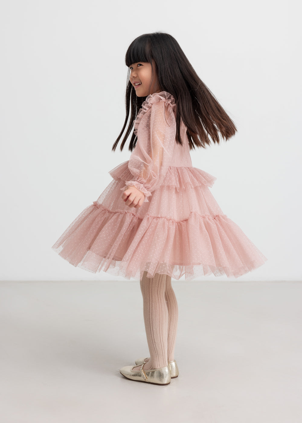 Børn iført rosa tylkjole med volanger på ærmerne